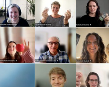Neun Personen in einem virtuellen Meeting, jede hält ein Objekt in der Hand. Einige zeigen Lebensmittel, andere Alltagsgegenstände.