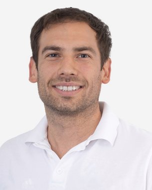 Ein Mann mit kurzen, braunen Haaren und einem freundlichen Lächeln trägt ein weißes Polohemd. Der Hintergrund ist neutral und hell.