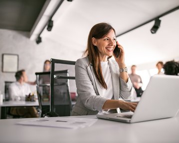 [Translate to Österreichisch:] Business Managerin am Schreibtisch